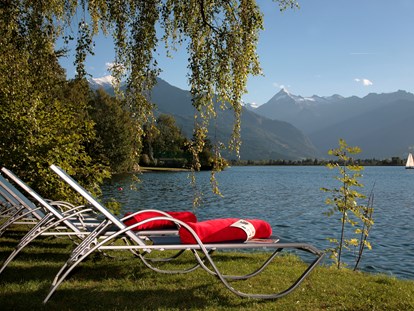 Familienhotel - Kirchdorf in Tirol - Hoteleigener Badestrand am Zeller See mit Matschplatz, Liegewiese, und kostenfreien Tretbooten - Familotel amiamo