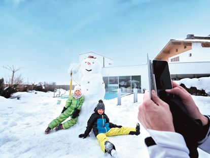 Familienhotel - Wellnessbereich - Spaß im Schnee auf der Hotelterrasse - Familotel amiamo