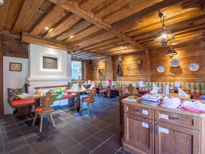 Familienhotel - Kirchdorf in Tirol - Kaminstube, Lätzchen, Besteck und Teller für Kleinkinder zum nehmen - Hotel babymio