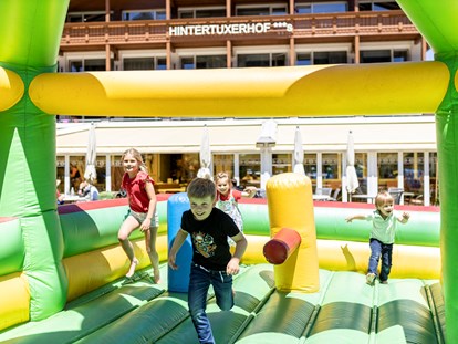 Familienhotel - Wellnessbereich - Hüpfburg Gaudi auf unserem Spielplatz - Kinder- & Gletscherhotel Hintertuxerhof