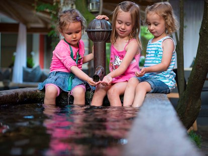Familienhotel - Wasserrutsche - Kinder am Brunnen - ULRICHSHOF Nature · Family · Design