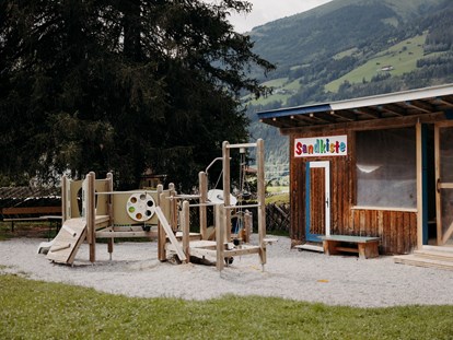 Familienhotel - Kirchdorf in Tirol - Spielplatz mit überdachter XXL-Sandkiste - Habachklause Familien Bauernhof Resort