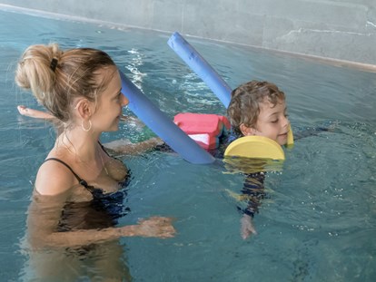 Familienhotel - Kinderbetreuung in Altersgruppen - Unsere zertifizierten Schwimmtrainer:innen üben mit den kleinen die ersten koordinierten Bewegungen im Wasser - ganz entspannt - Gorfion Familotel Liechtenstein